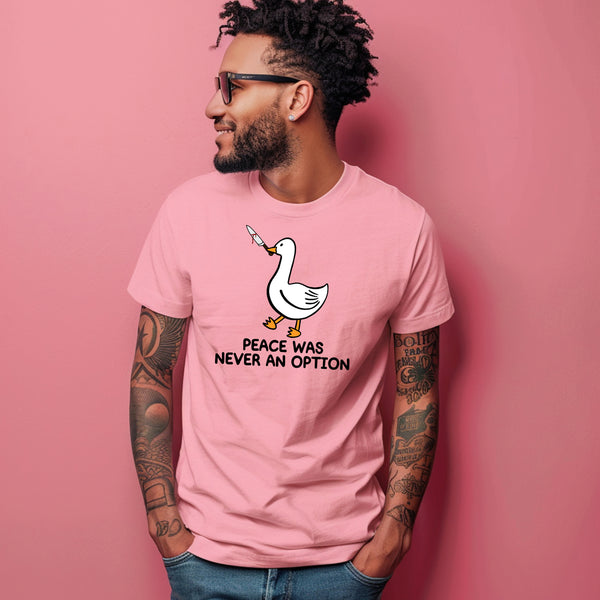 Front view of a male model wearing the Peace Was Never An Option Funny Duck Men's Graphic T-Shirt in pink. Male model is wearing sunglasses standing in front of a pink wall.