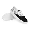 A pair of Orca Snork "Goofy Pup" women's canvas sneakers, with the right shoe propped up to show the bottom sole. The shoes have a black and white print of goofy dogs and hearts.