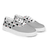 A pair of Orca Snork Playful One-Eyed Cat Canvas Sneakers presented at an angle, showcasing the vibrant pattern of our one-eyed feline, Orca, along with paw prints, hearts, fishbones, and blue fish.