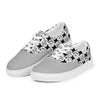 A pair of Orca Snork Playful One-Eyed Cat Canvas Sneakers floating on white background, showcasing a dynamic front view of the vibrant pattern of our one-eyed feline, Orca, along with paw prints, hearts, fishbones, and blue fish.